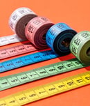 colorful measuring tapes top view on bright red background
