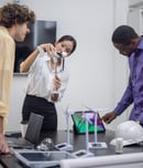 A diverse startup team develop, collaborates on a powerful, lightweight, portable wind turbine prototype, aligning with potential user demand and renewable energy needs to secure investor funding.