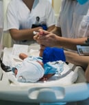 Team of professional doctors and nurses examining newborn baby at the hospital.