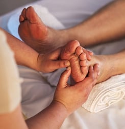 Closeup, feet and spa therapist with massage, pedicure and relax with health, wellness and acupress.