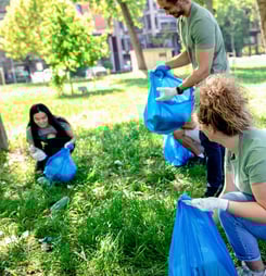 Multiethnic group of volunteers with garbage bags cleaning city