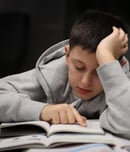 A boy is doing homework, he reading homework, education, teenager boy, learning, back to school.