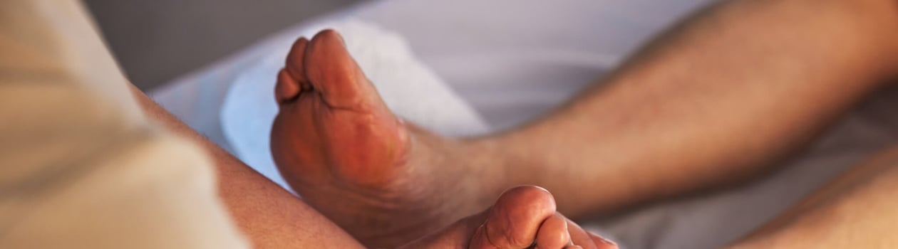 Closeup, feet and spa therapist with massage, pedicure and relax with health, wellness and acupress.