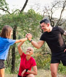 family giving a high five during their training in the woods