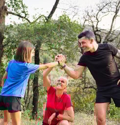 family giving a high five during their training in the woods
