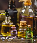 Glass bottles aroma oil, zen stones and dry lavender flowers on wooden table.