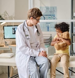 Pediatrist talking to child at office