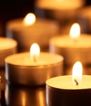 selective focus of burning candles glowing in darkness, panoramic shot