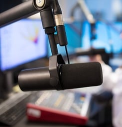 Studio Microphone in Radio Station with Female Host Using Control Panel and Sound Mixer In Background